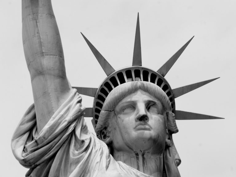 Image of the statue of liberty's face close up, in black and white. Immigration attorney.