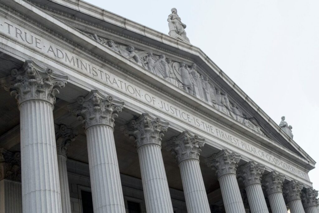 Contact Immigration attorney.. Image of a federal building against grey sky
