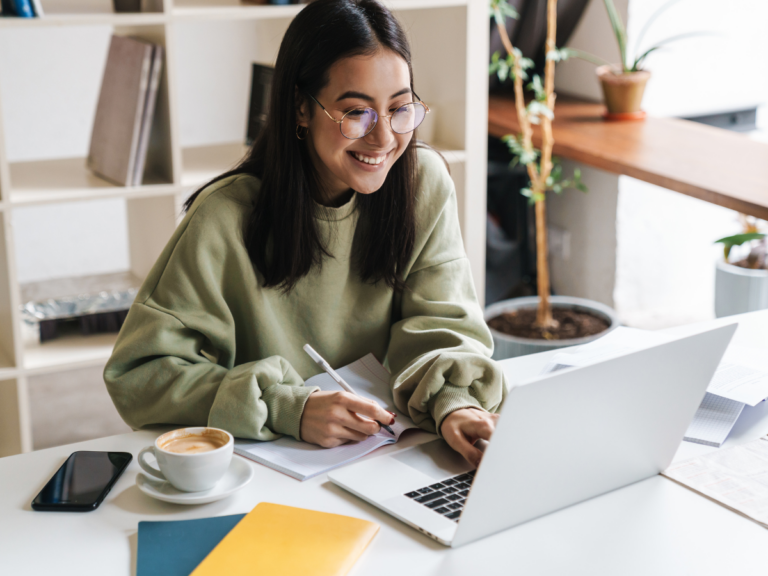 Student smiling sitting at laptop. Student visa immigration.